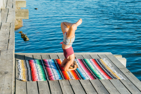 Women doing yoga posture on Mexican blanket
