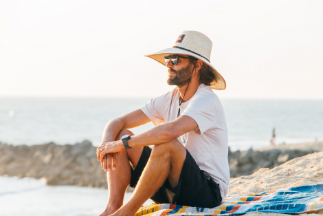 Man with straw hat looking at the beach