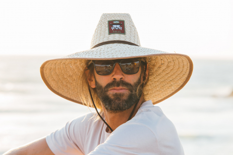 Man in lifeguard straw hat looking at the camera