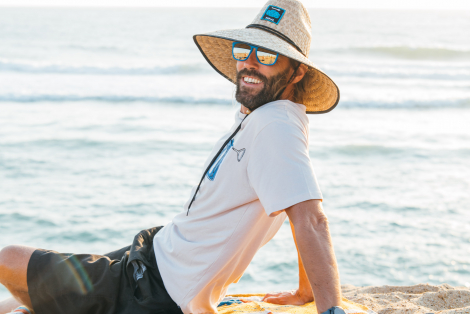 Man at the beach smiling with Pakal Californian hat and blue sunglasses