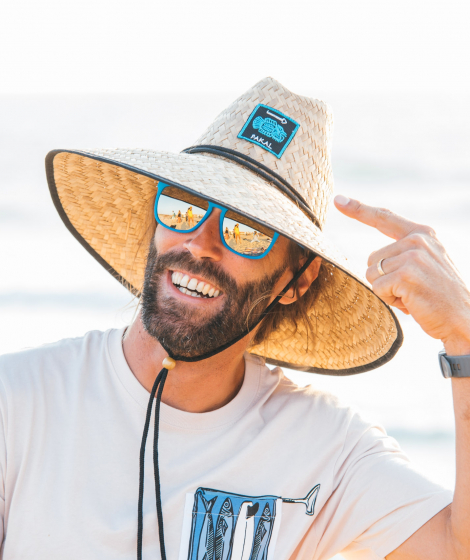 Man with beach straw hat pointing at the logo