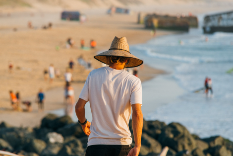 man walking at the beach with beach straw hat Pakal