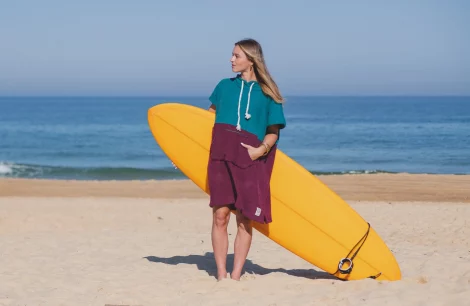 Woman surfer in bicolor beach poncho Green and Burgundy