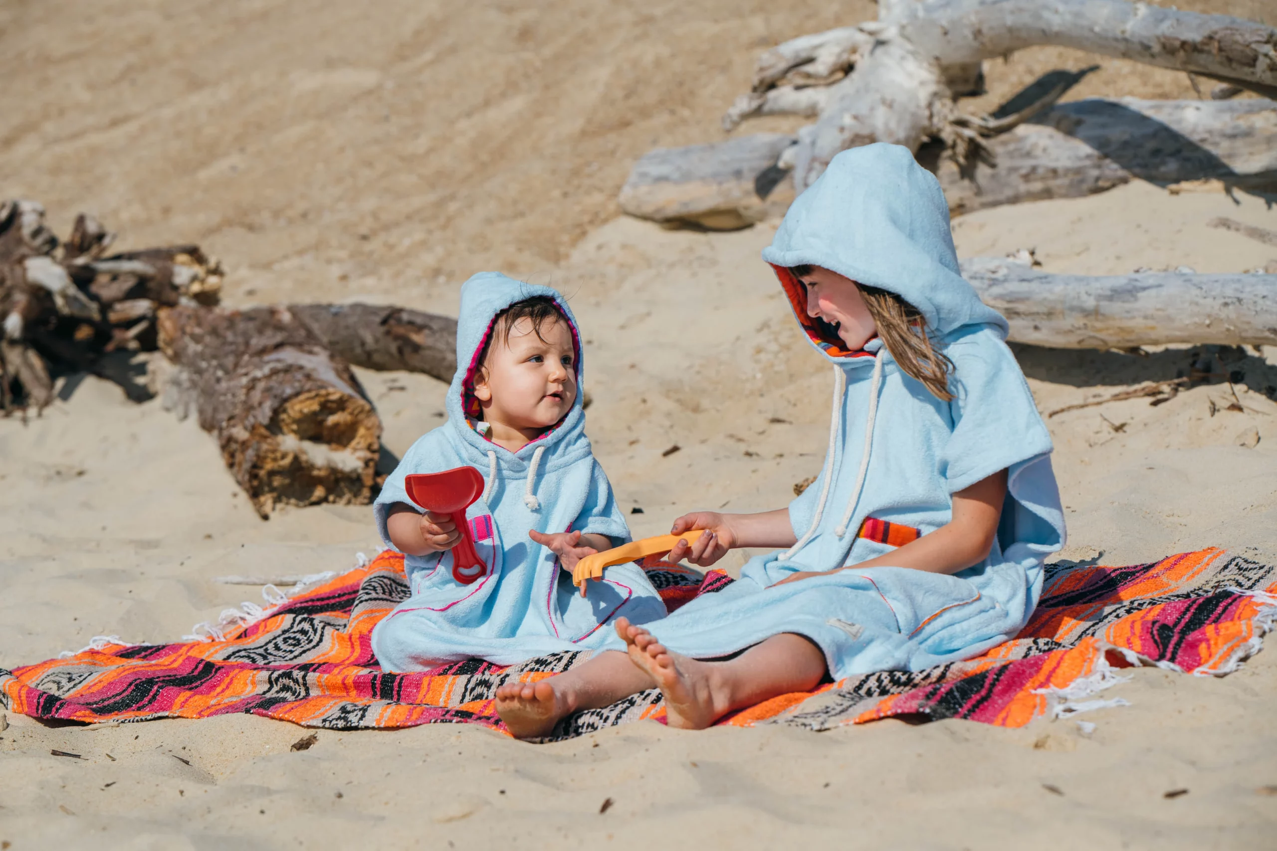 Pakal-2026-compressé-_JérémieGabrien-20 Poncho de Bain Enfant Eponge Coton Bleu Ciel / Motif Arc-en-ciel Orange